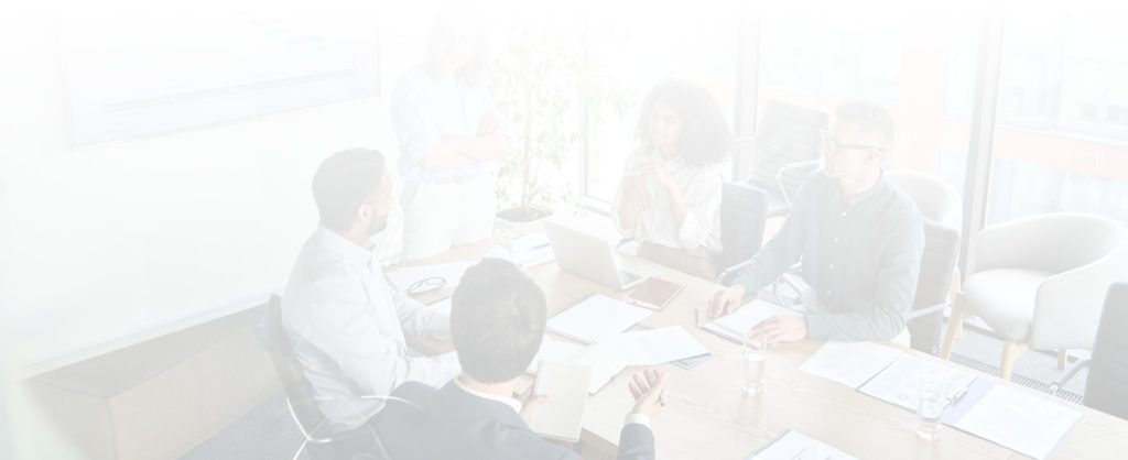 a group of people are sitting around a table having a meeting .