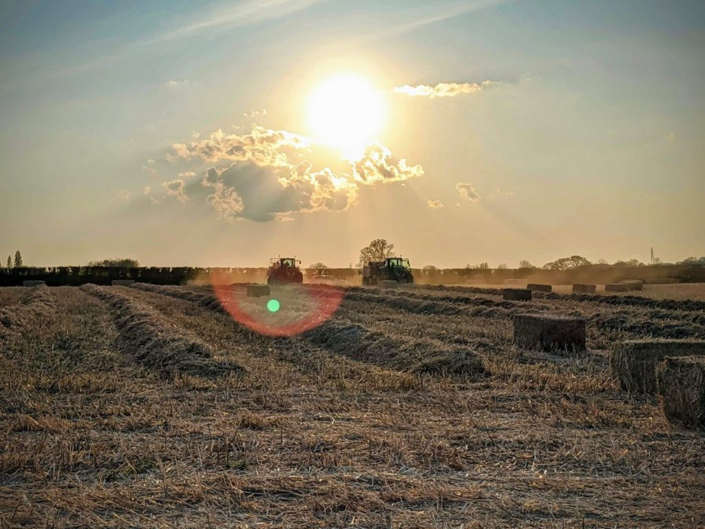 Two tractors plowing a field under a sunny sky to relate to farm credit